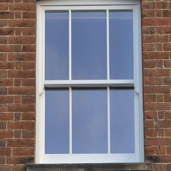 Timber sash window with glazing bars in a brick arch opening, Dorking, Surrey