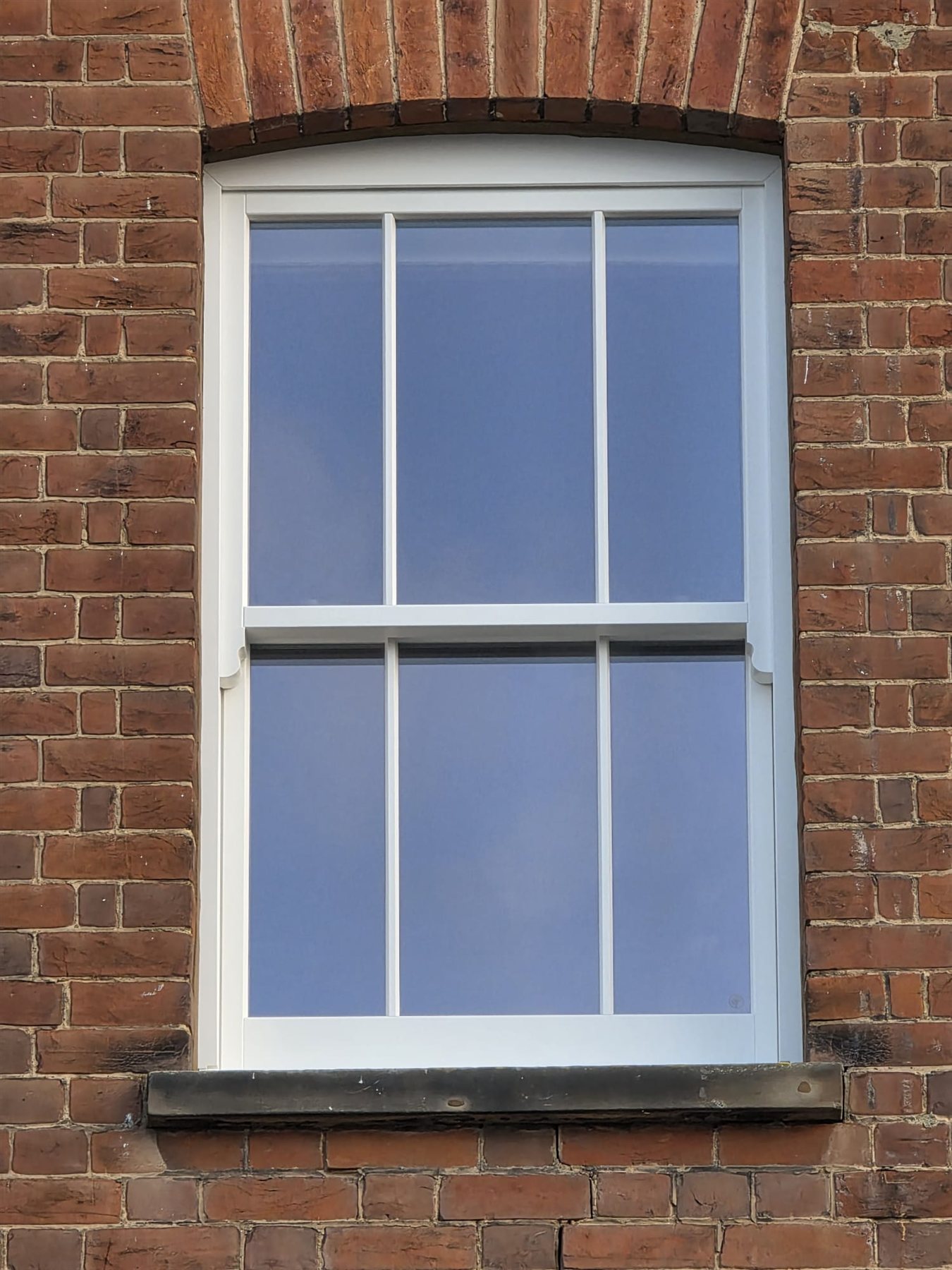 Timber sash window with glazing bars in a brick arch opening, Dorking, Surrey