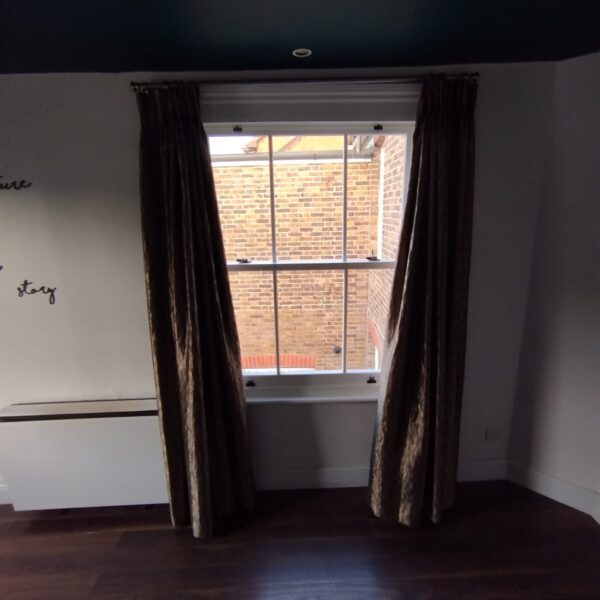 Inside view of a timber sash window with curtains, Dorking, Surrey